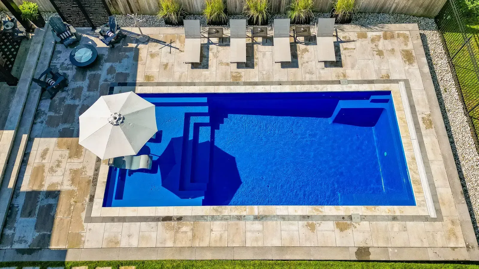 An aerial view of a large swimming pool with a white umbrella.
