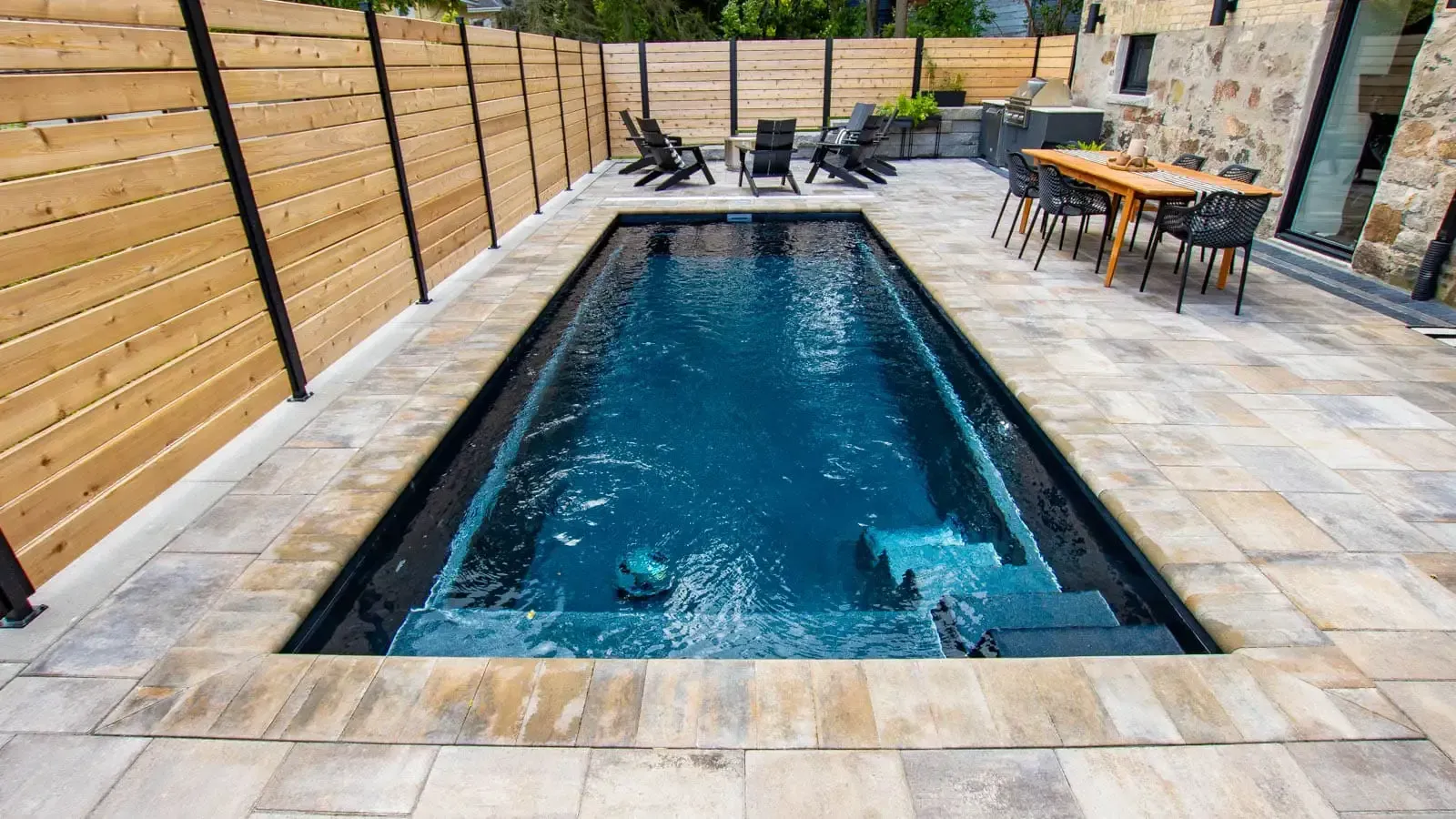 Long shot of The Vision Pool Range in Volcanic Black featuring a gorgeous hardscape surrounding it. 
