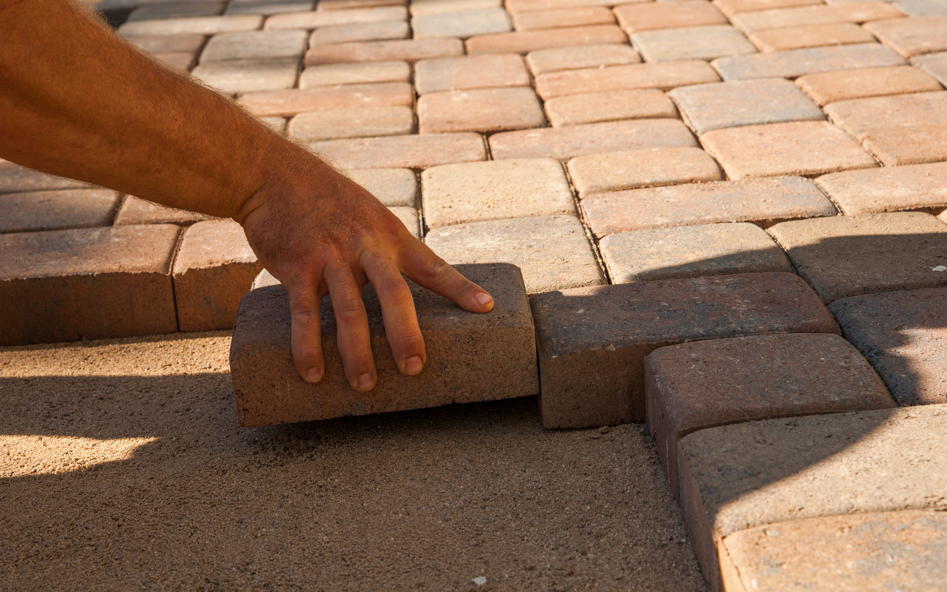 hand placing a brick for a brick porch