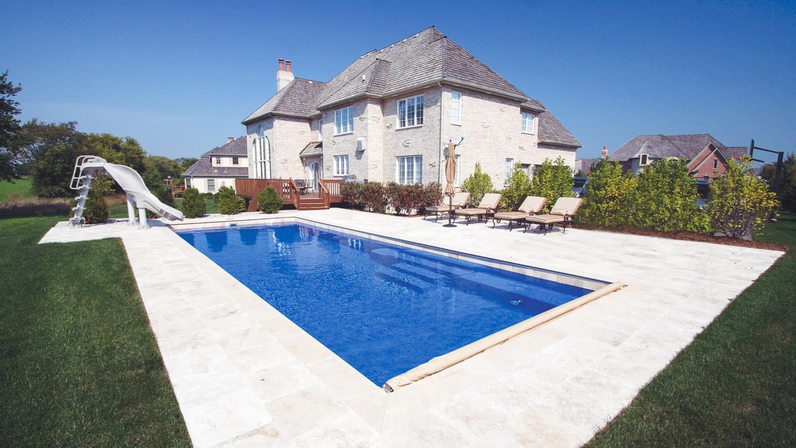 A large house with a large swimming pool in front of it featuring The Celebration Pool Layout by Poor Boy