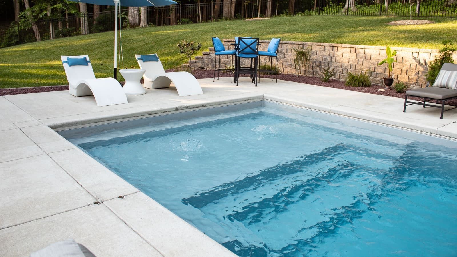 Splash pad, steps, and entry to the shallow end of The Illusion Pool Range by Poor Boy