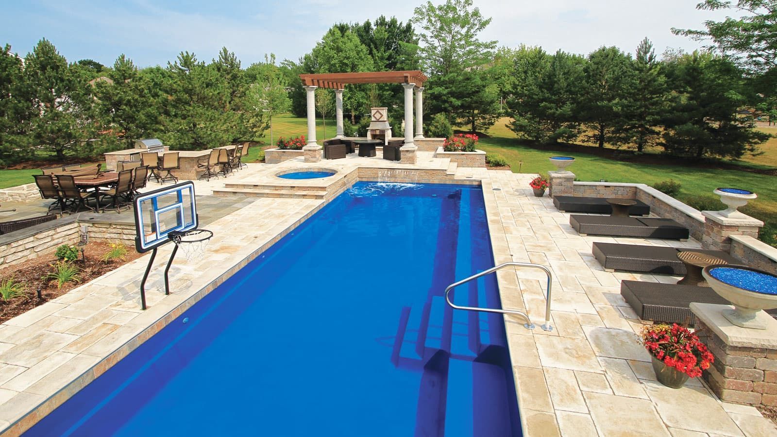 A large blue swimming pool is surrounded by chairs and a gazebo.