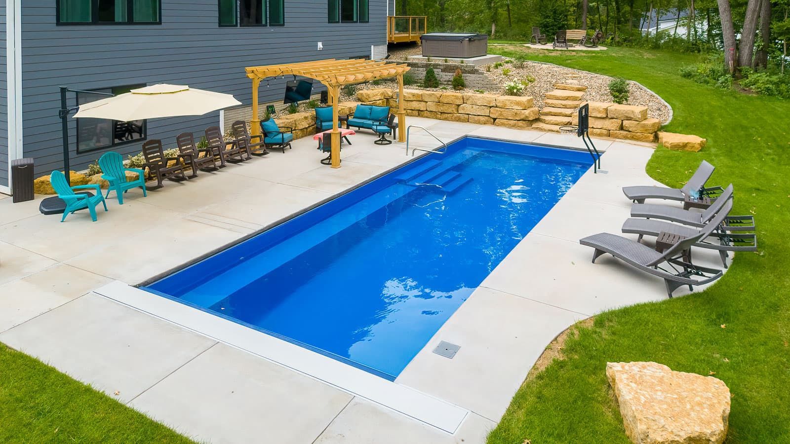 There is a large swimming pool in the backyard of a house.