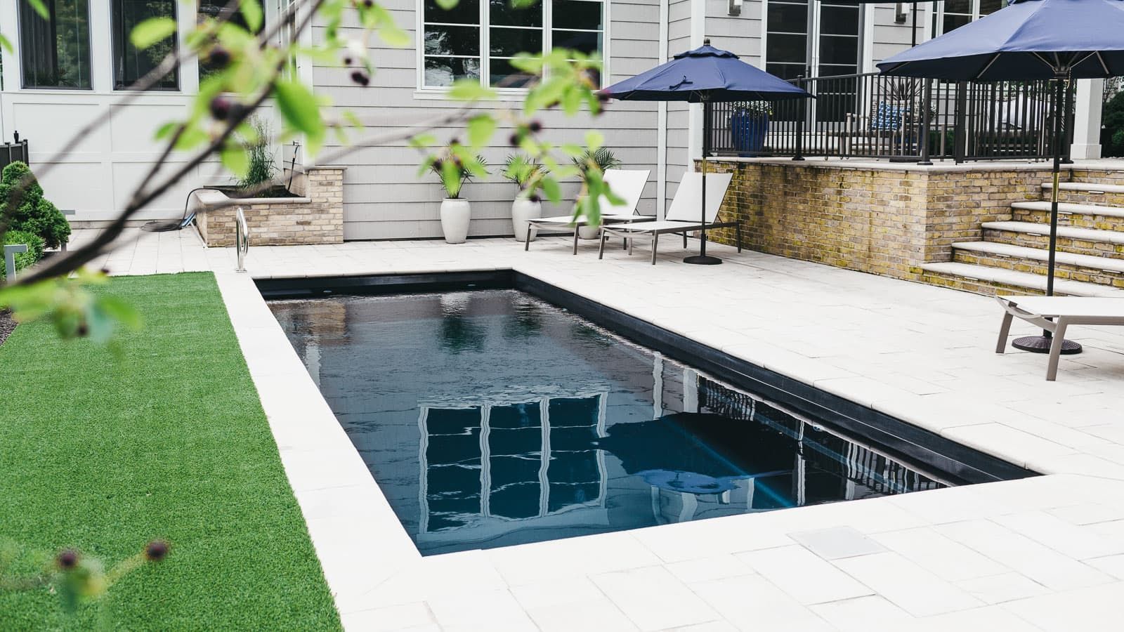 The Vision Pool Range is pictured as a large swimming pool in the backyard of a house.