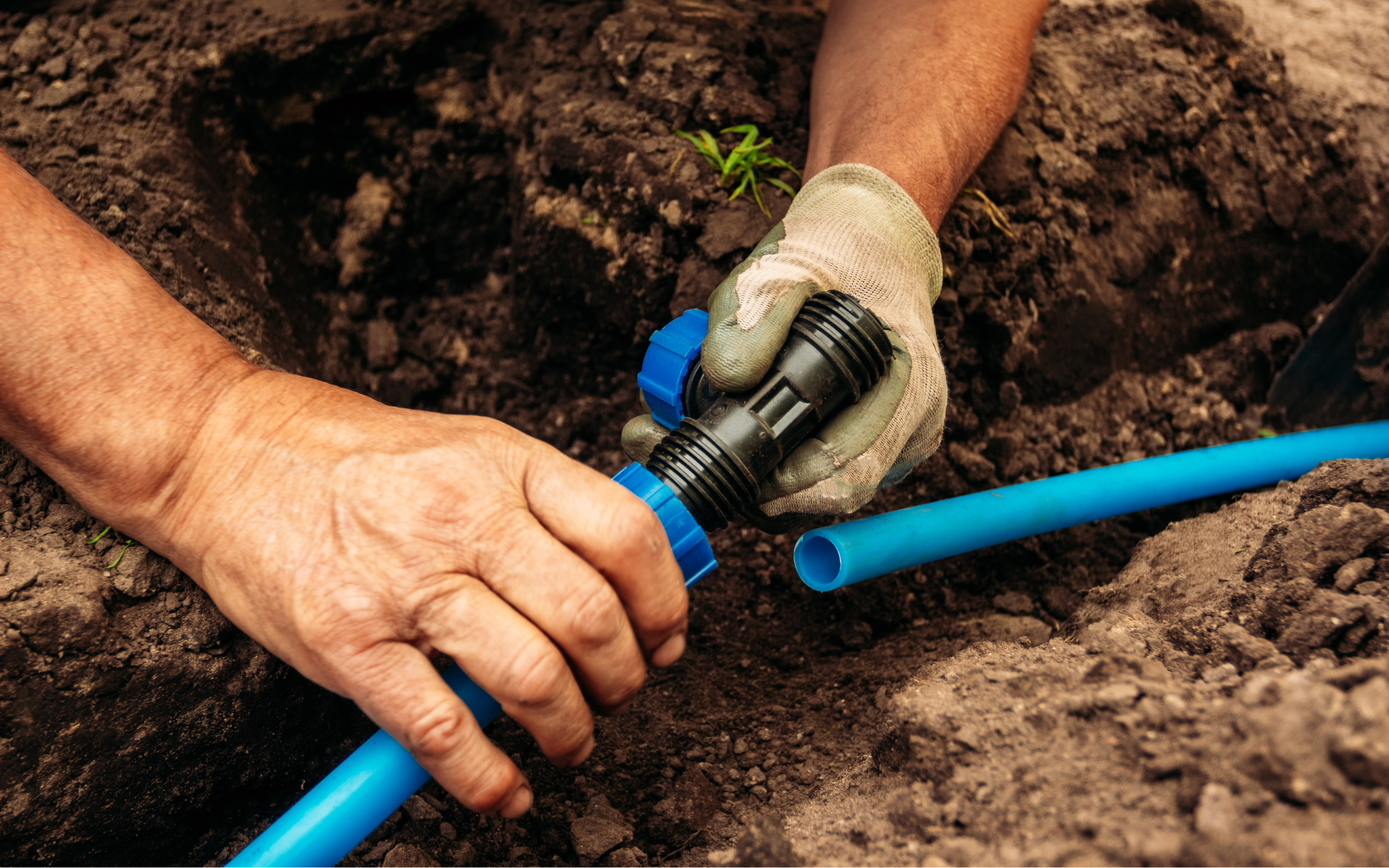 Hands of a poor boy worker replacing an underground hose system for irrigation and sprinkler systems