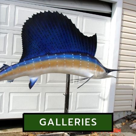 A realistic taxidermy sailfish mounted on a pole stand in front of a white garage door, with a green 