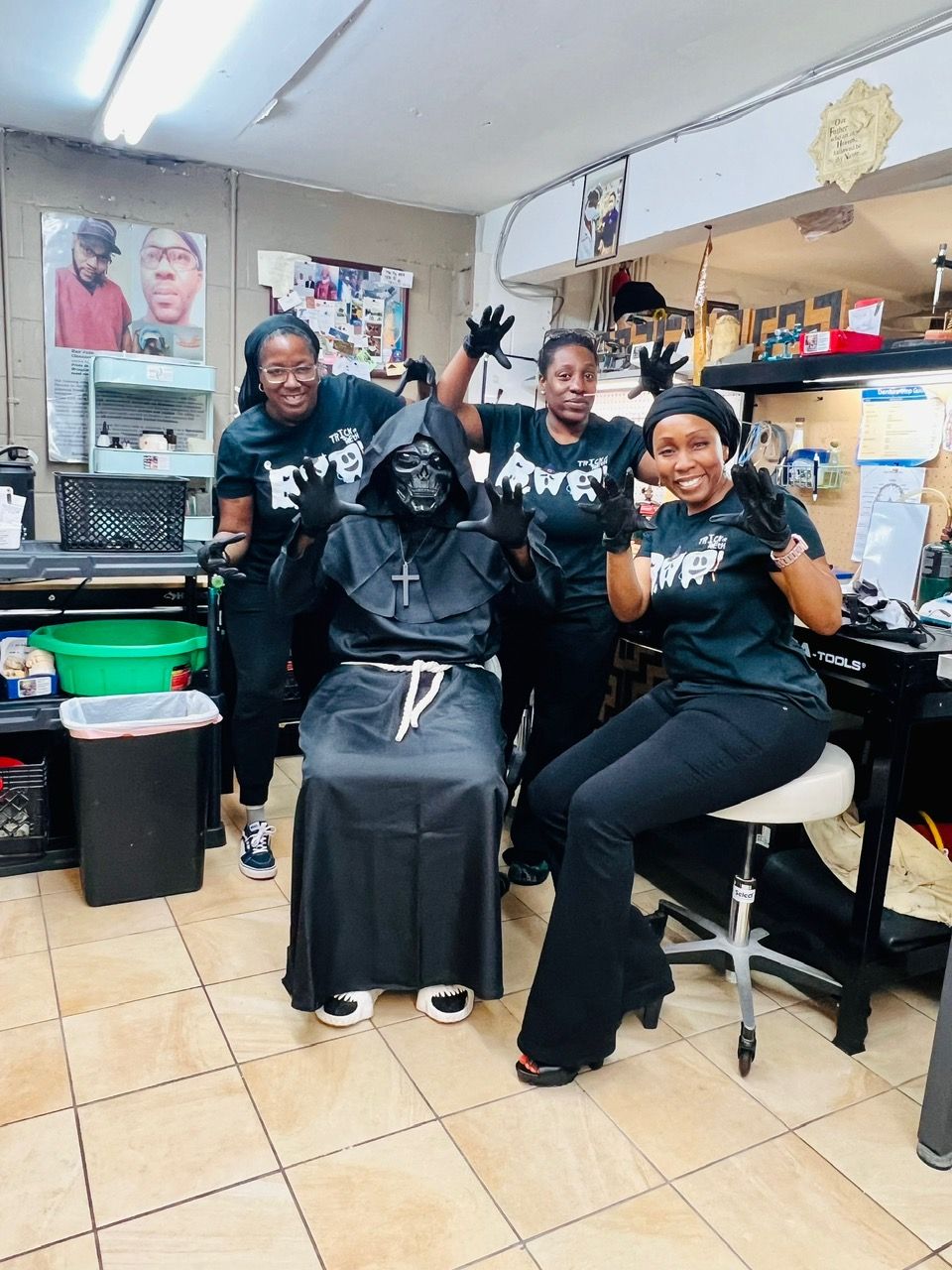 A group of people are posing for a picture in a room with a statue of darth vader.