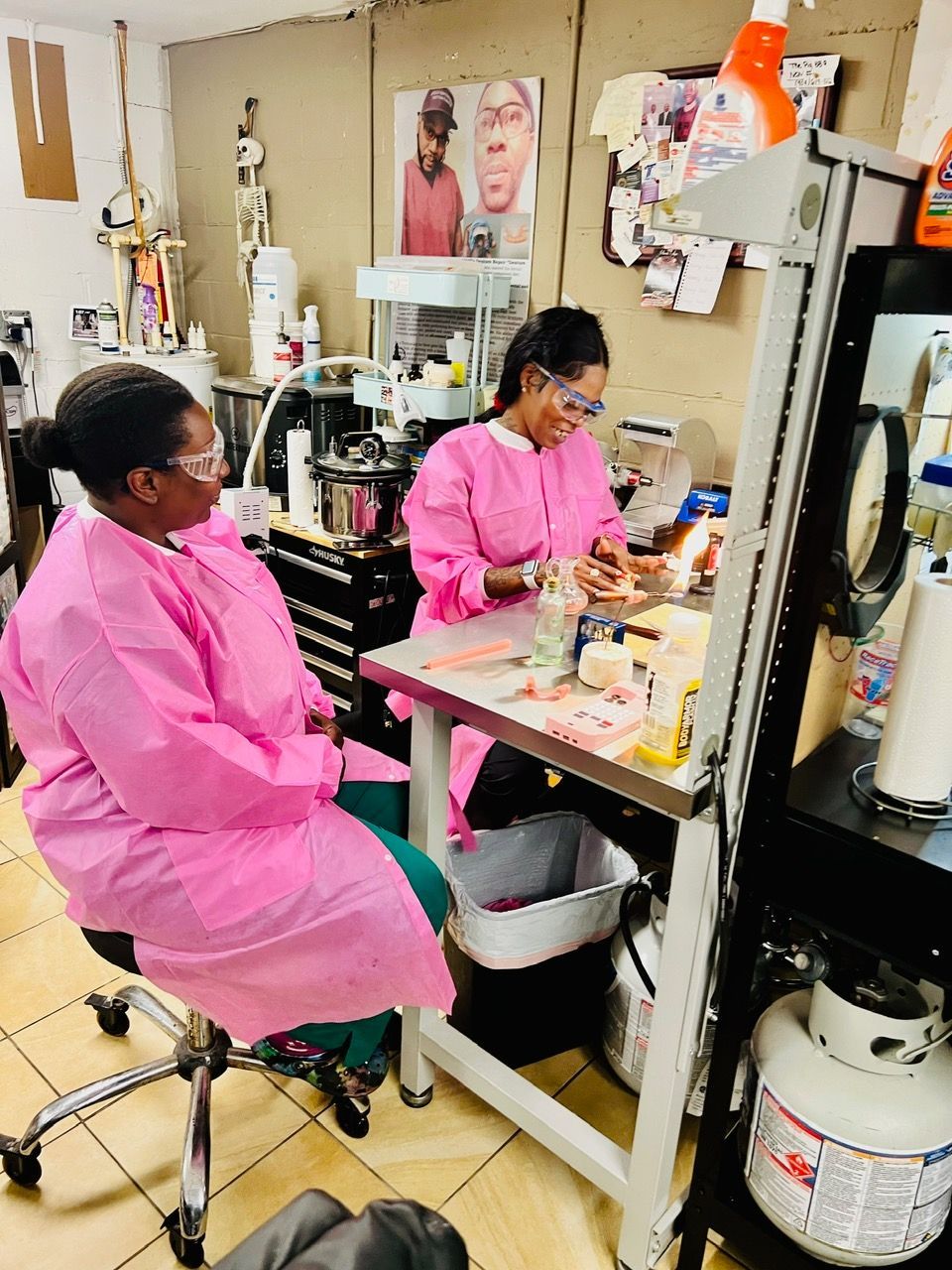 Two women in pink gowns are working in a lab.