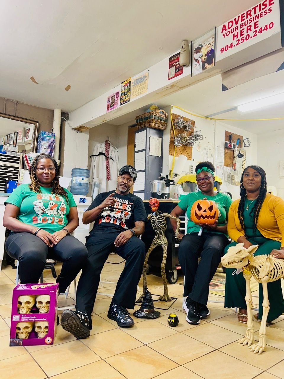 A group of people are sitting in a room holding pumpkins.