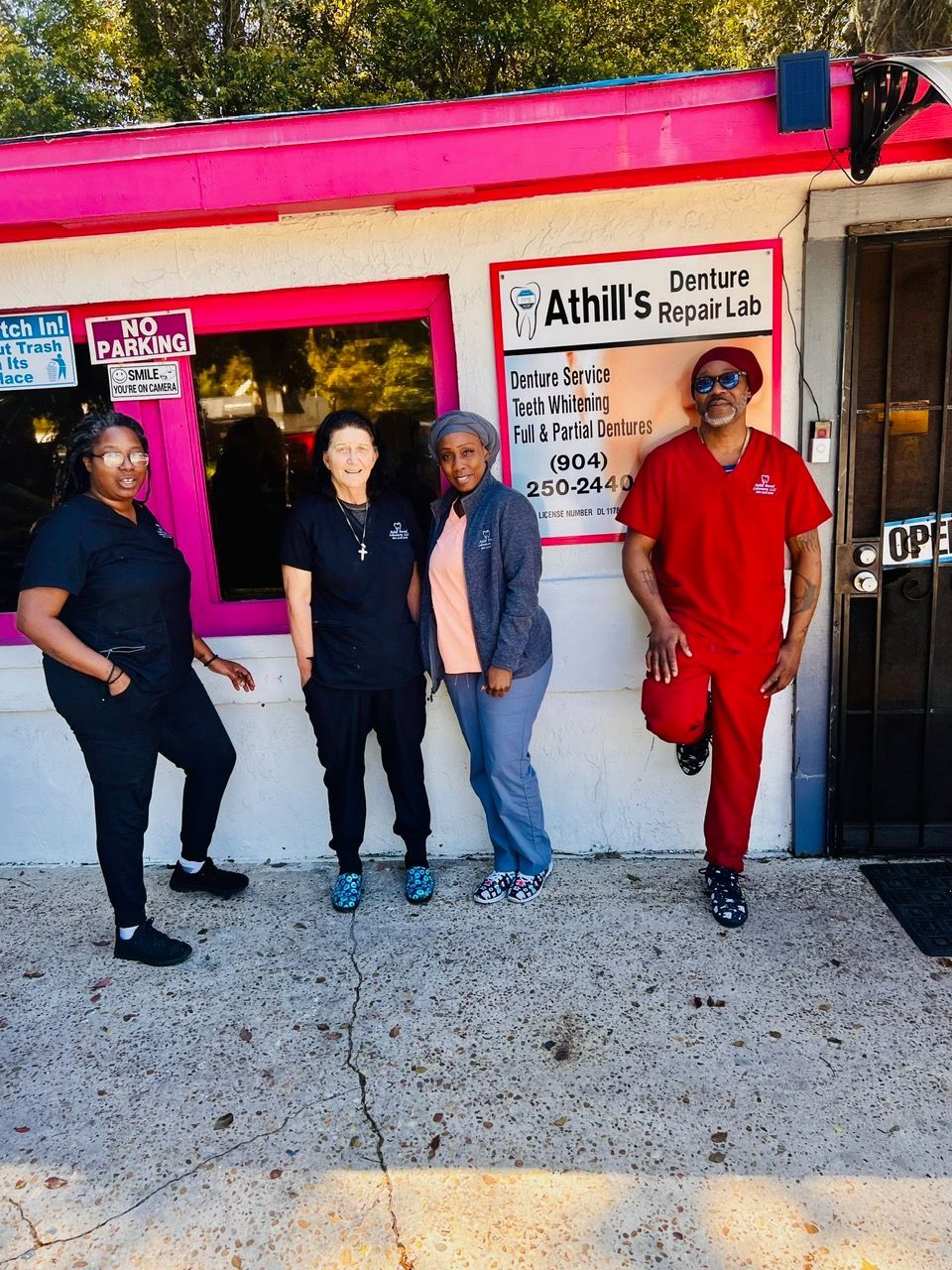 A group of people standing in front of a pink building.