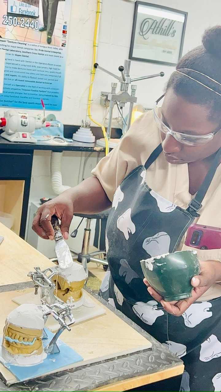 A woman is working on a dental model in a dental lab.