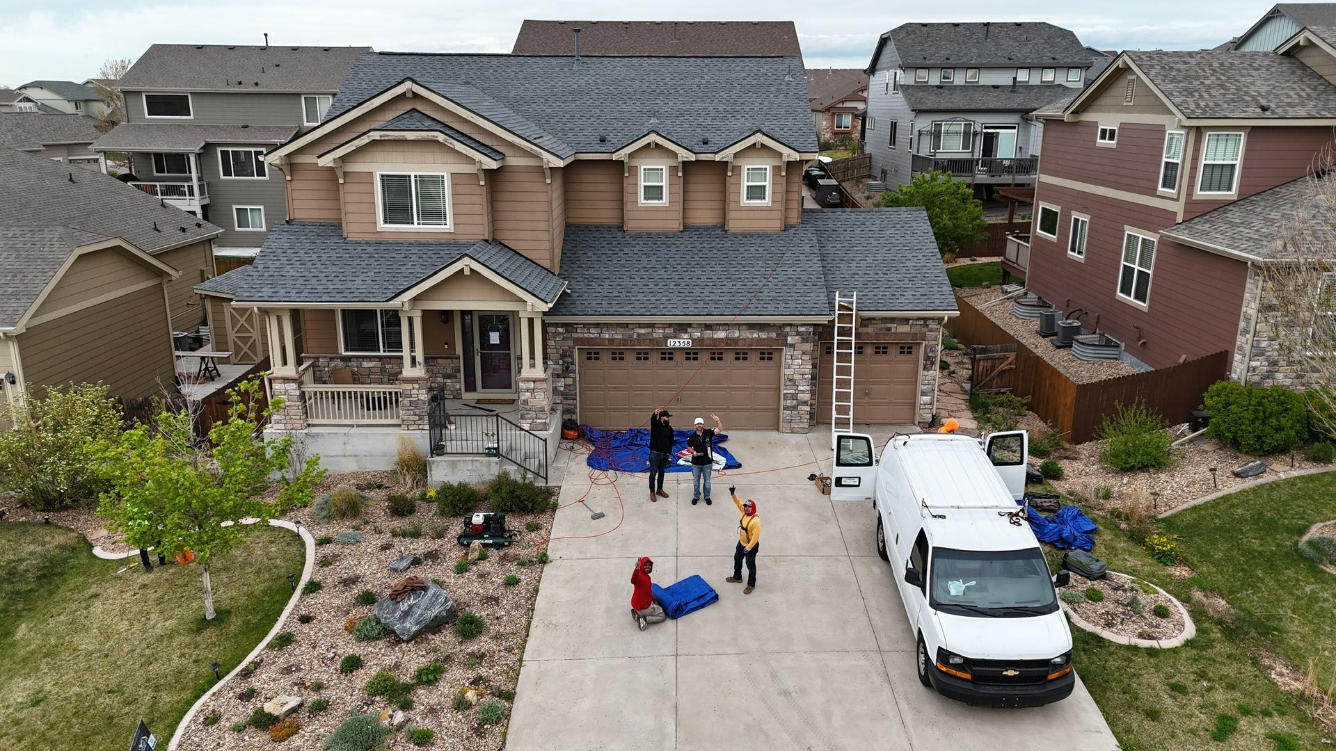 An aerial view of a house with a van parked in front of it.