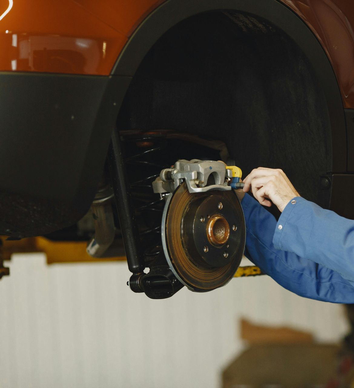 Man Repairing Car Brake System | Performance Fast Lube