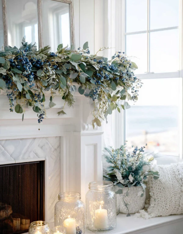Fireplace mantel decorated with blue and green garland, candles in jars, and a window view. Fireplace mantel decorated with blue and green garland, candles in jars, and a window view.