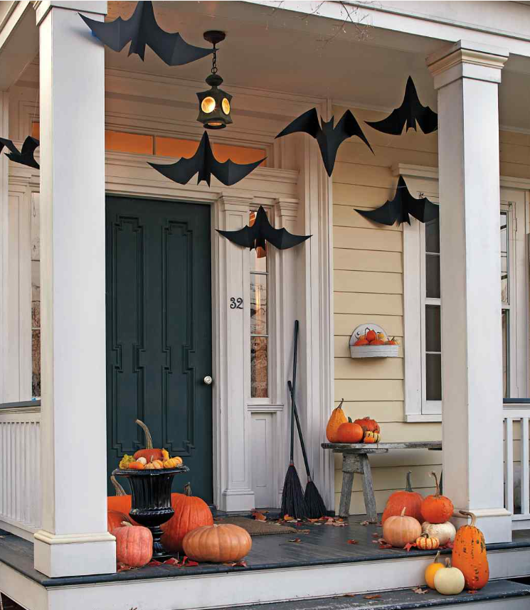 Halloween-decorated porch: paper bats, pumpkins, brooms, and a hanging lantern. Tooltip Halloween-decorated porch: paper bats, pumpkins, brooms, and a hanging lantern.