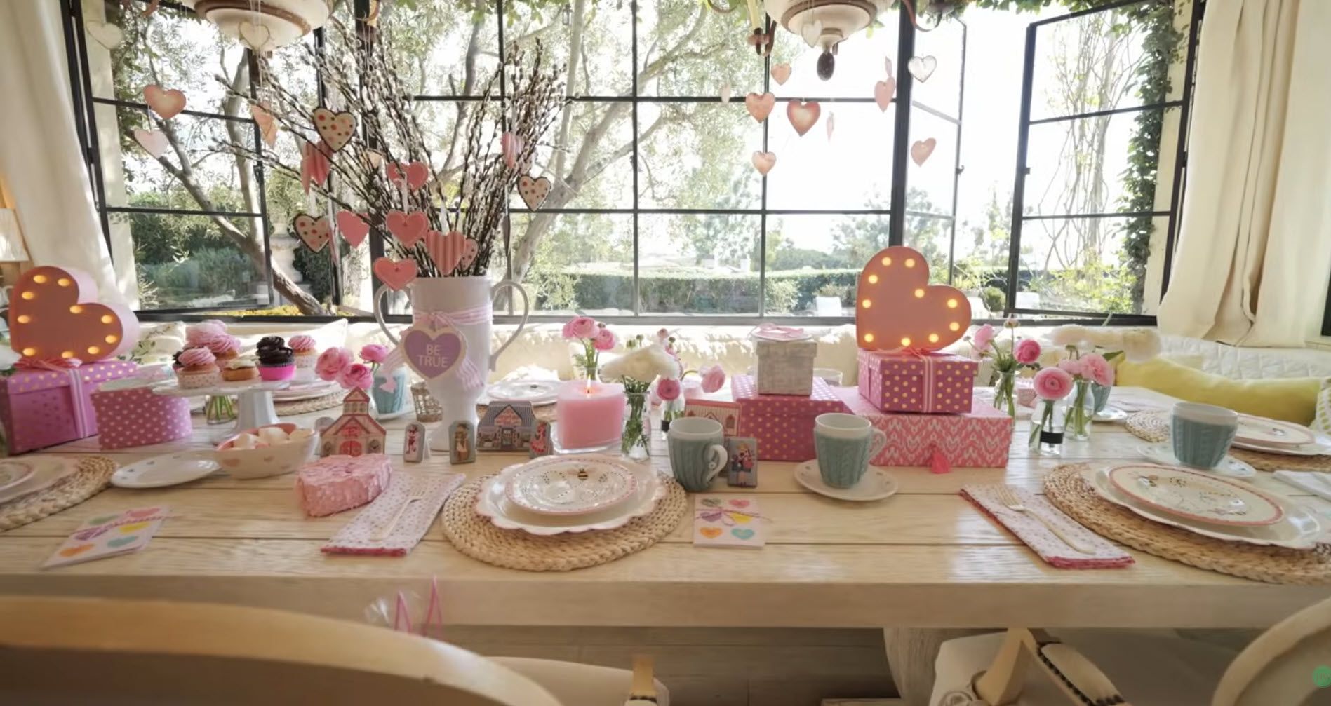 A festive foyer with a large decorated Christmas tree and garland-adorned staircase.