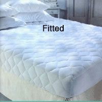 A bed with a fitted mattress protector and pillows on it.