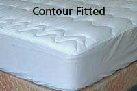 A white mattress with a contour fitted mattress protector on it.