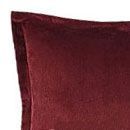 A close up of a red pillow on a white background.