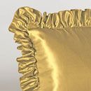A close up of a gold pillow with ruffles on it.