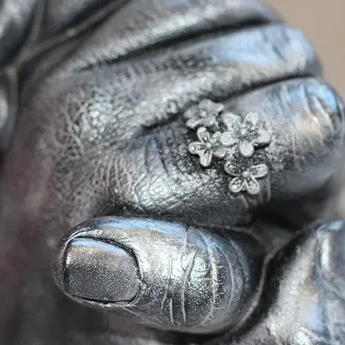 A close up of a person 's hand with a ring on it.