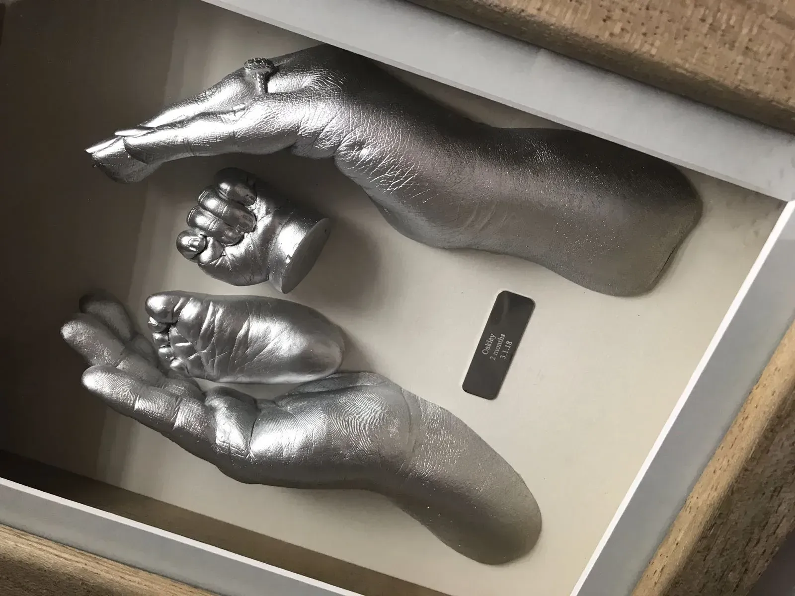 A picture of a baby 's hand and foot in a box.