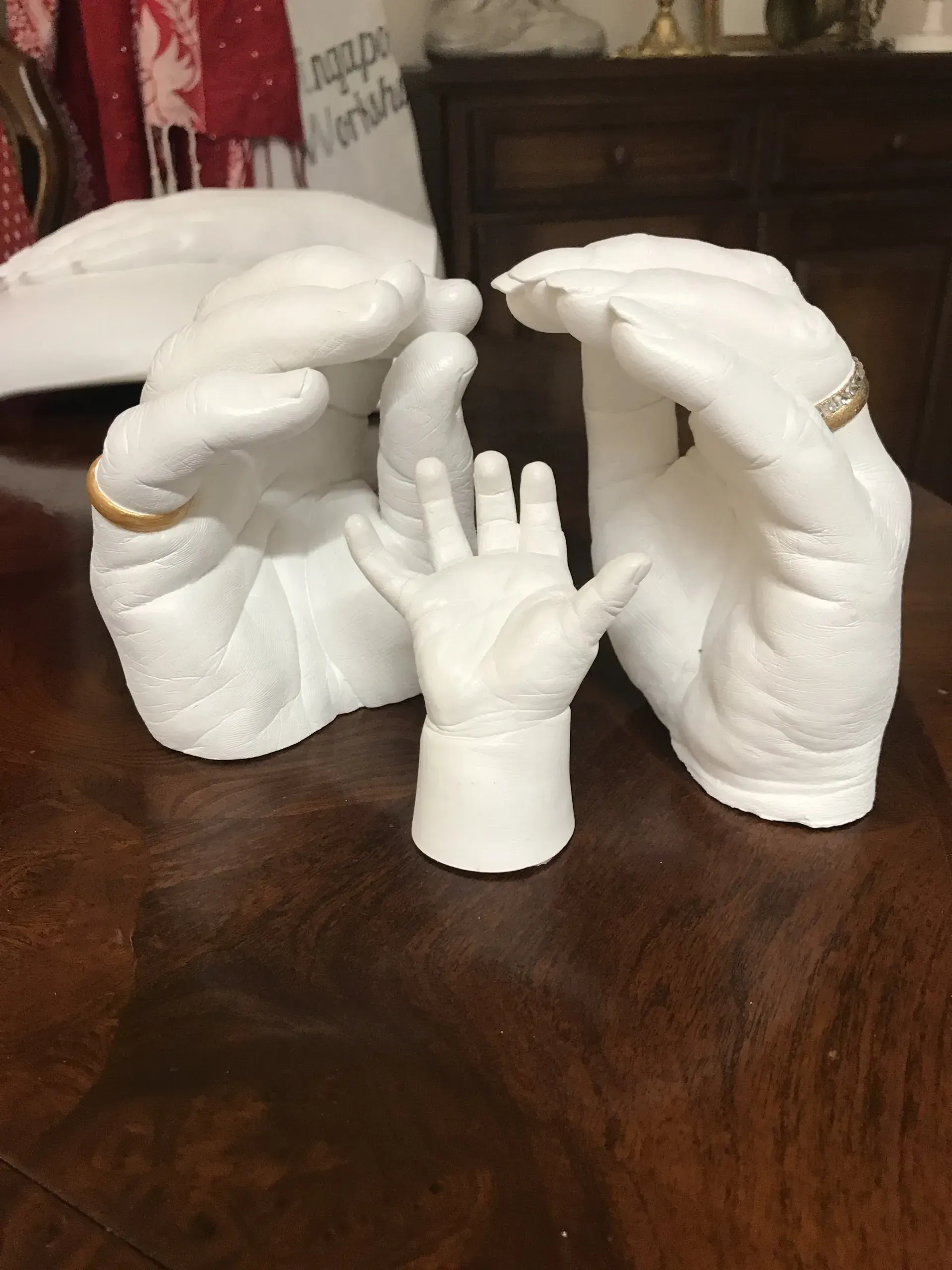 A statue of a woman holding a baby 's hand on a table