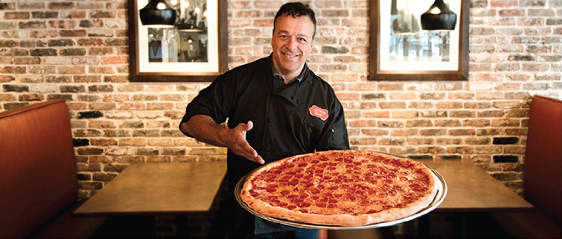 Chef Russo Holding Large Party Pizza