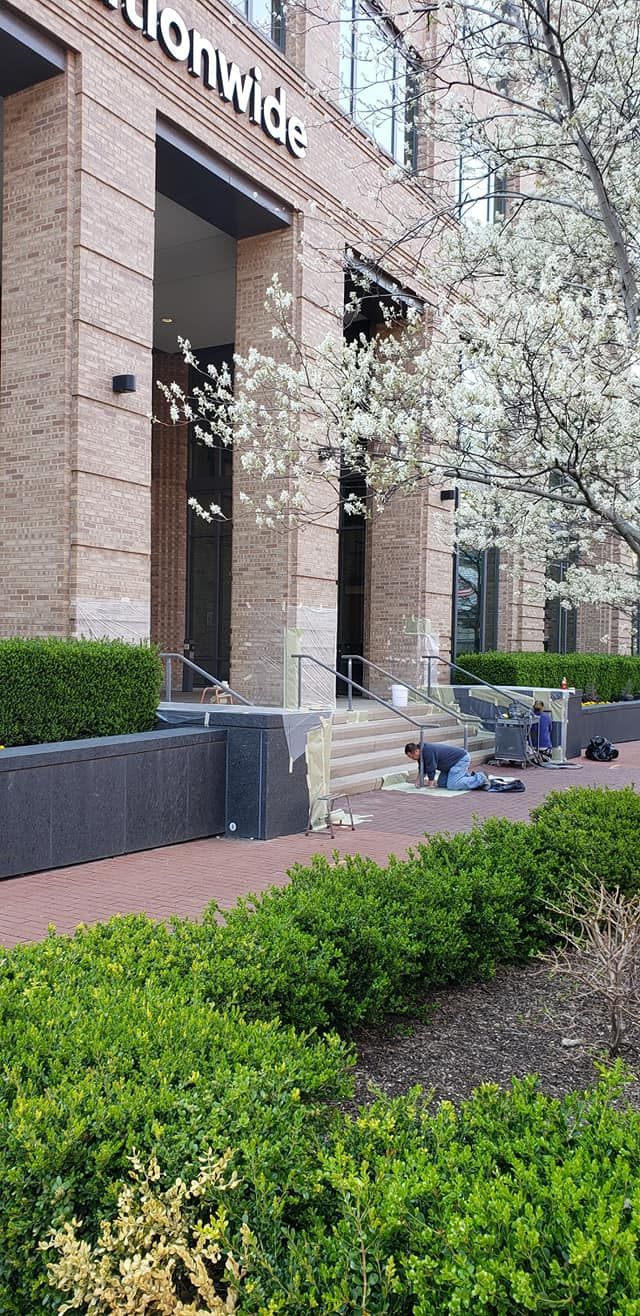 Exterior view of a Nationwide building with a brick facade and landscaping.  People are working by the entrance.