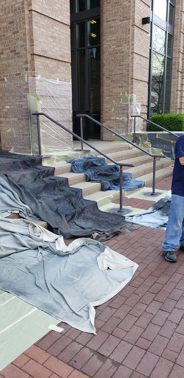 A building entrance covered with tarps and stairs; a person stands on the right.