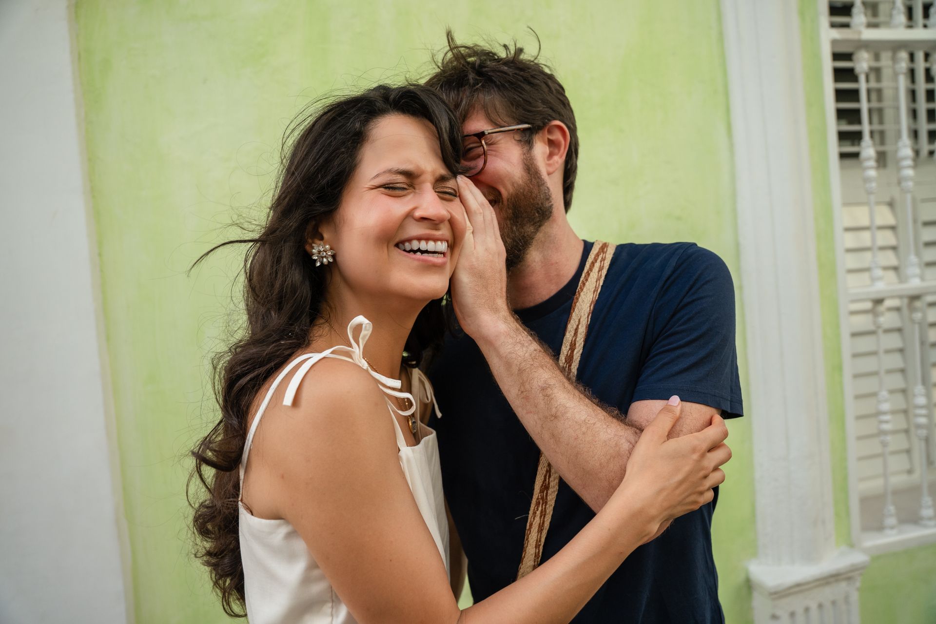 Una pareja sonriente se encuentra al aire libre.
