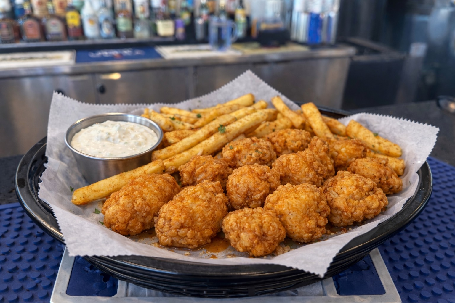 A plate of fried mozzarella sticks with a bowl of tomato sauce.