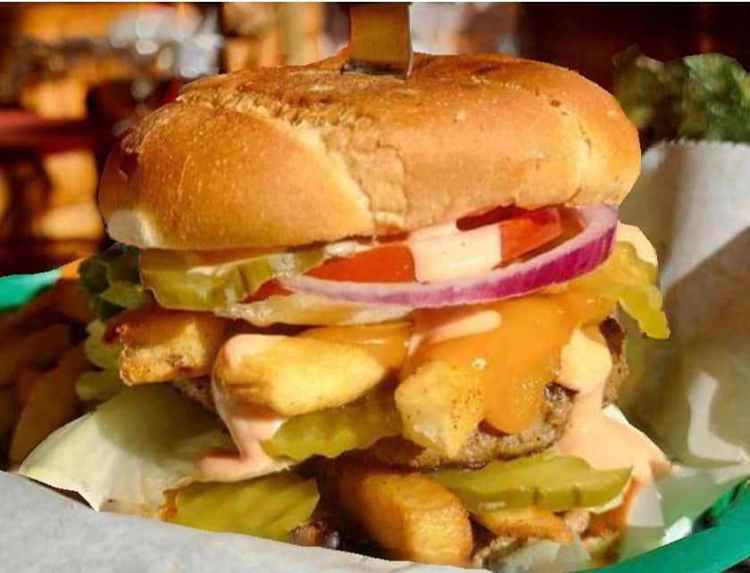 A close up of a hamburger and french fries in a basket