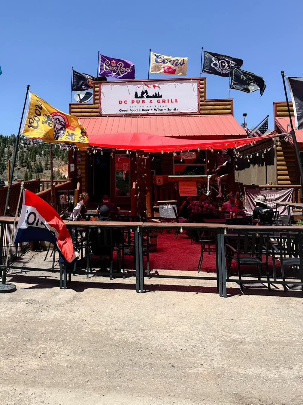 A restaurant with a red awning and flags on top of it