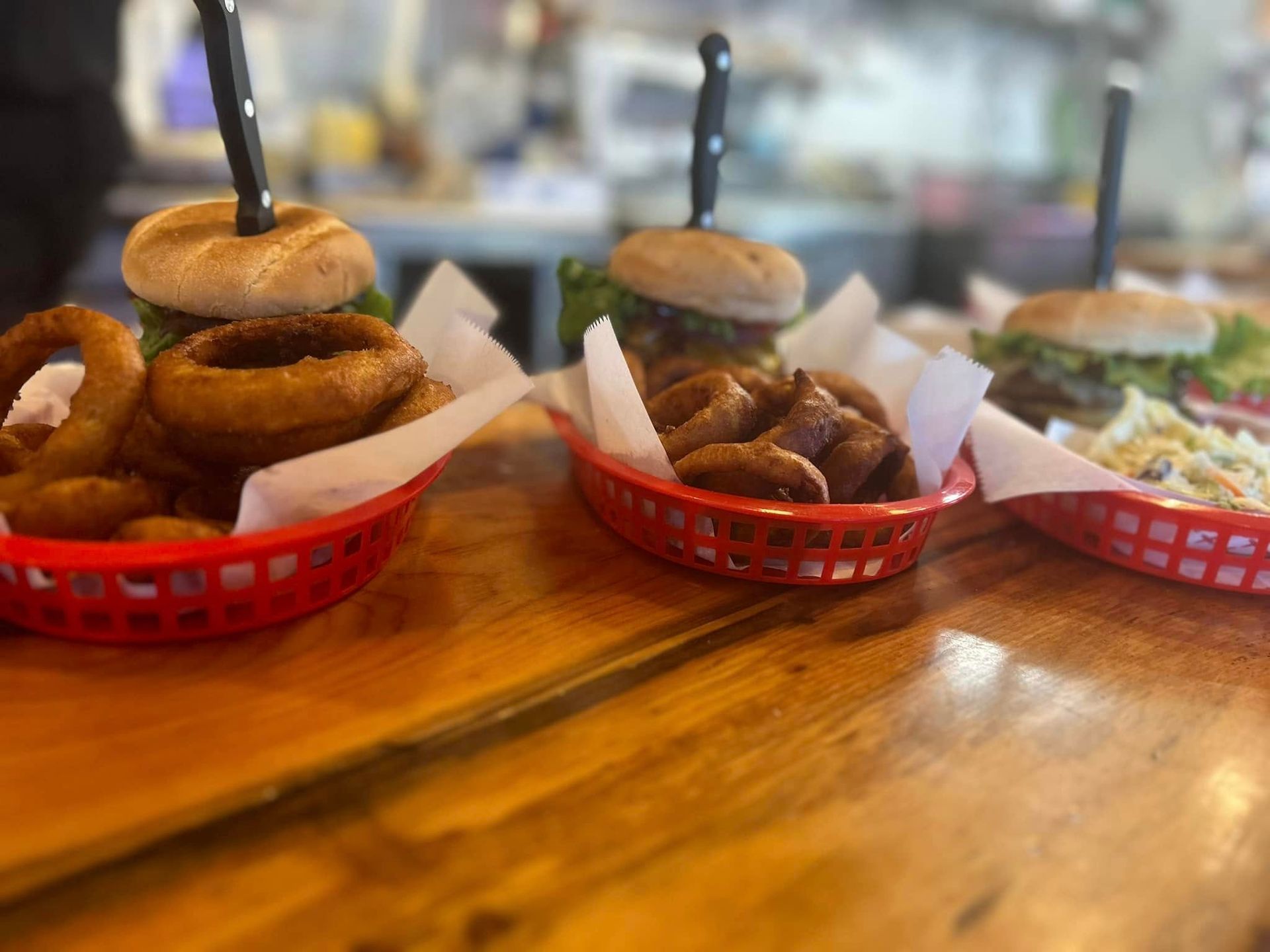 Three baskets of food are sitting on a wooden table.