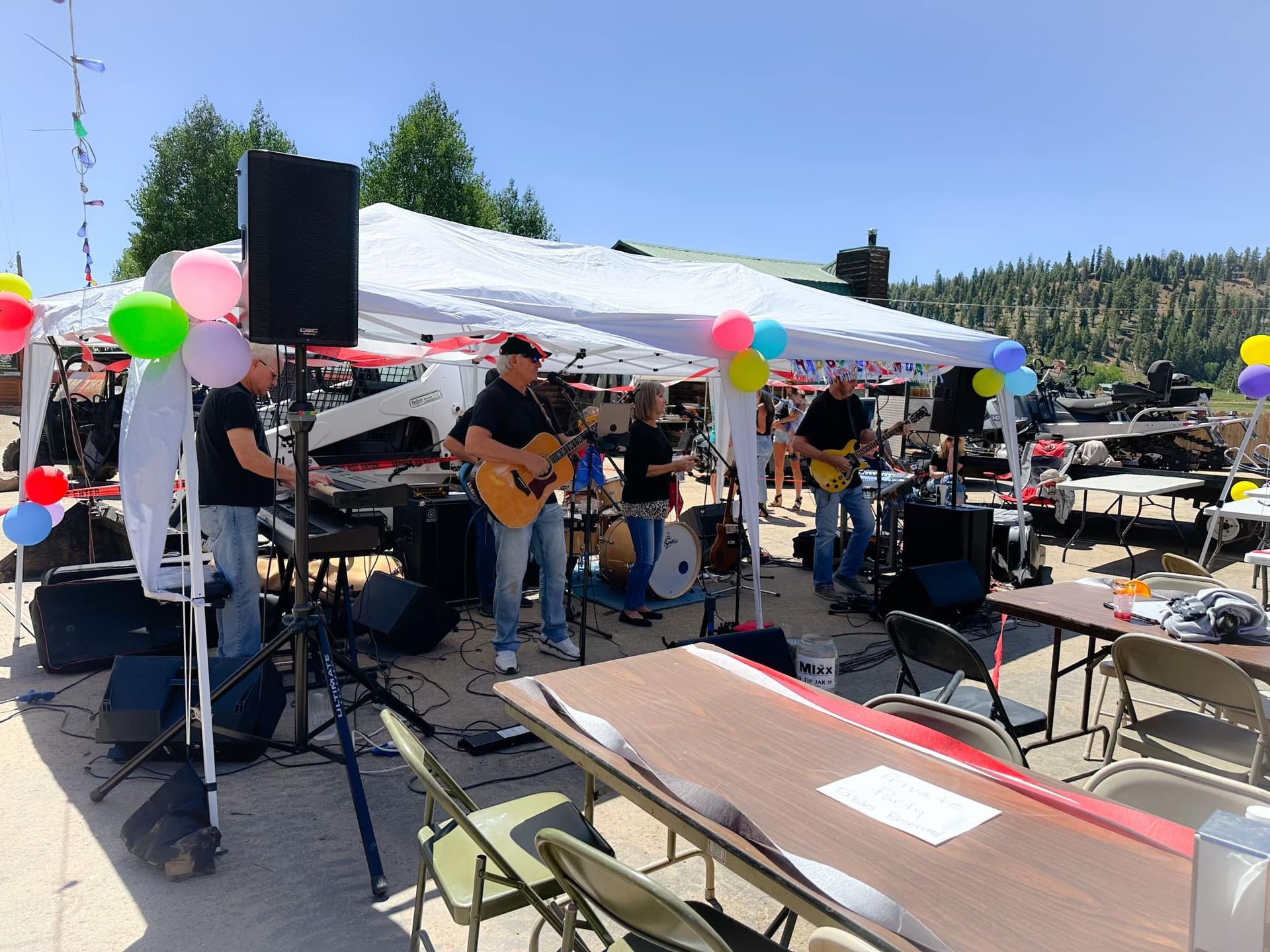 A group of people are playing instruments under a tent.