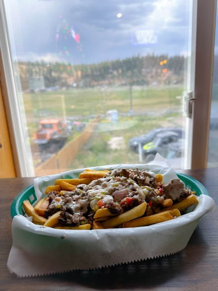 A basket of french fries is sitting on a table in front of a window.