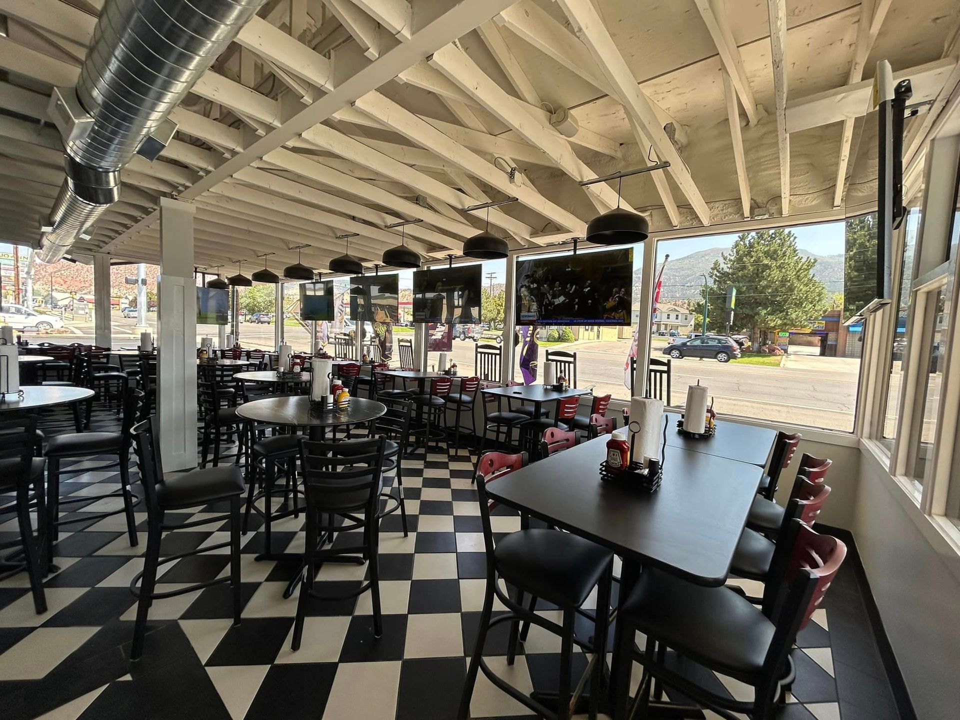 A restaurant with tables and chairs and a checkered floor.
