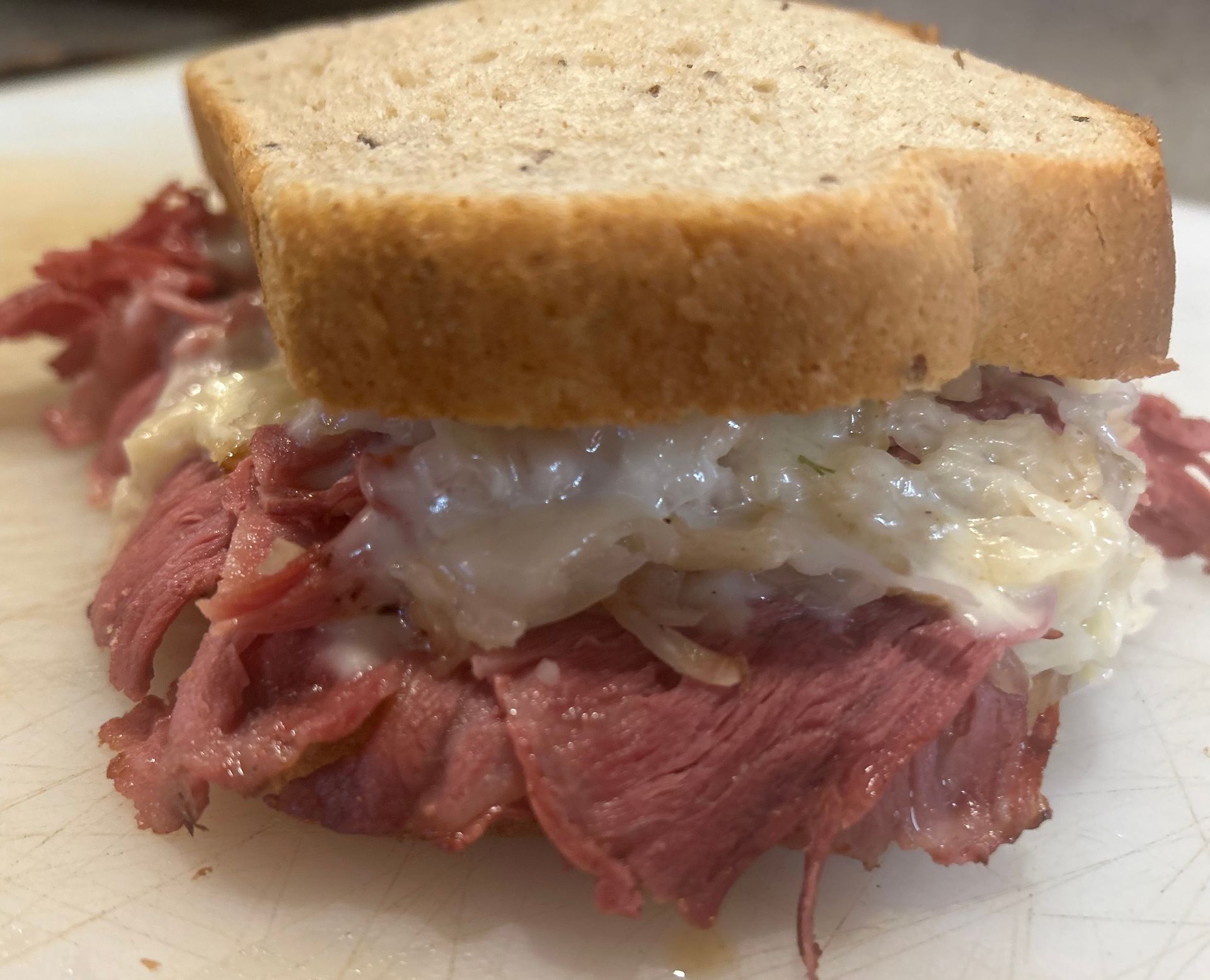 A close up of a corned beef sandwich on a cutting board