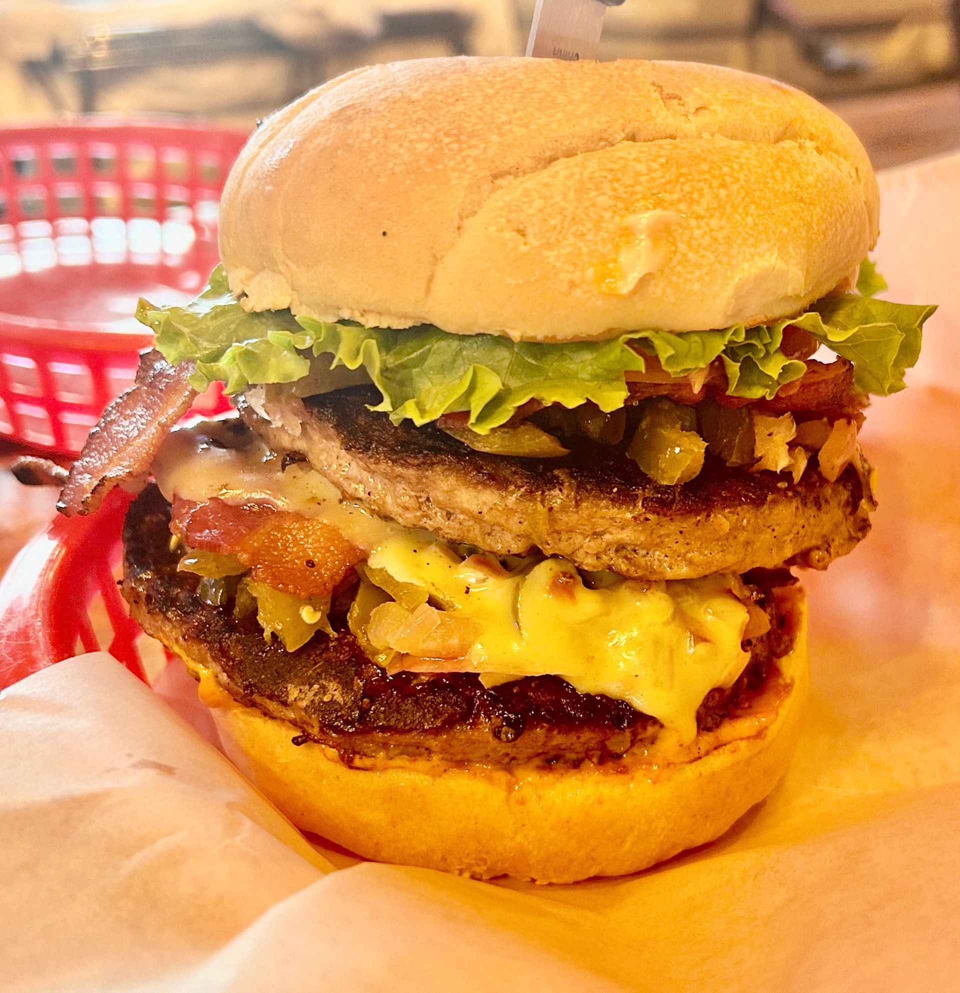 A hamburger with lettuce bacon and cheese on a bun