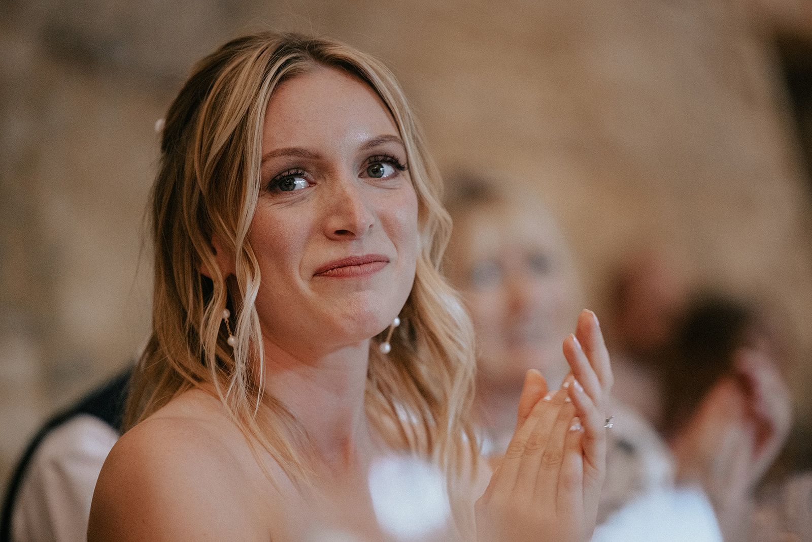 A woman is clapping her hands at a wedding reception.