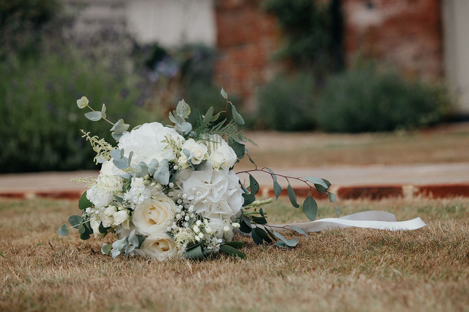 A bouquet of white flowers is laying on the ground.
