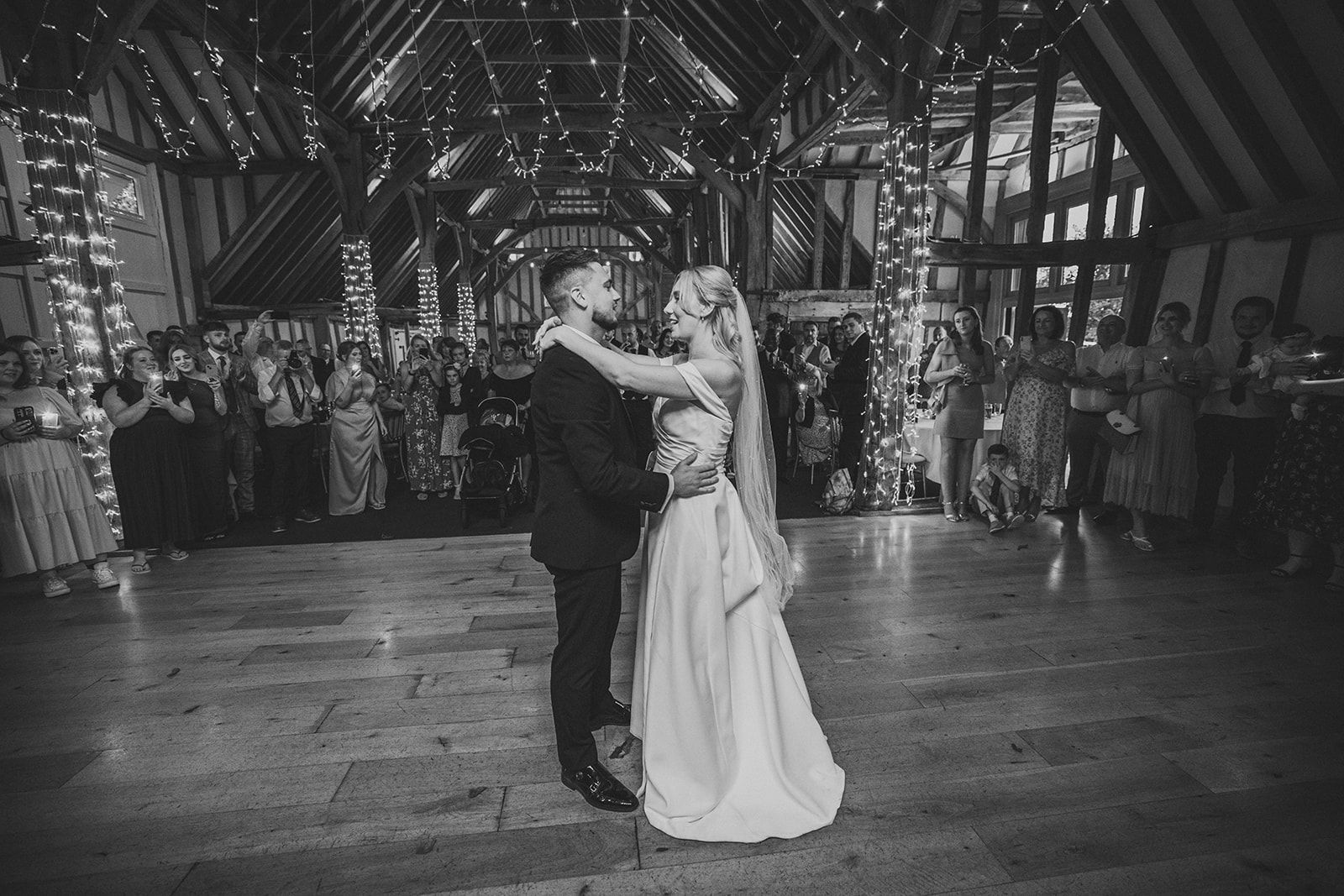 A bride and groom are standing next to each other on a path.