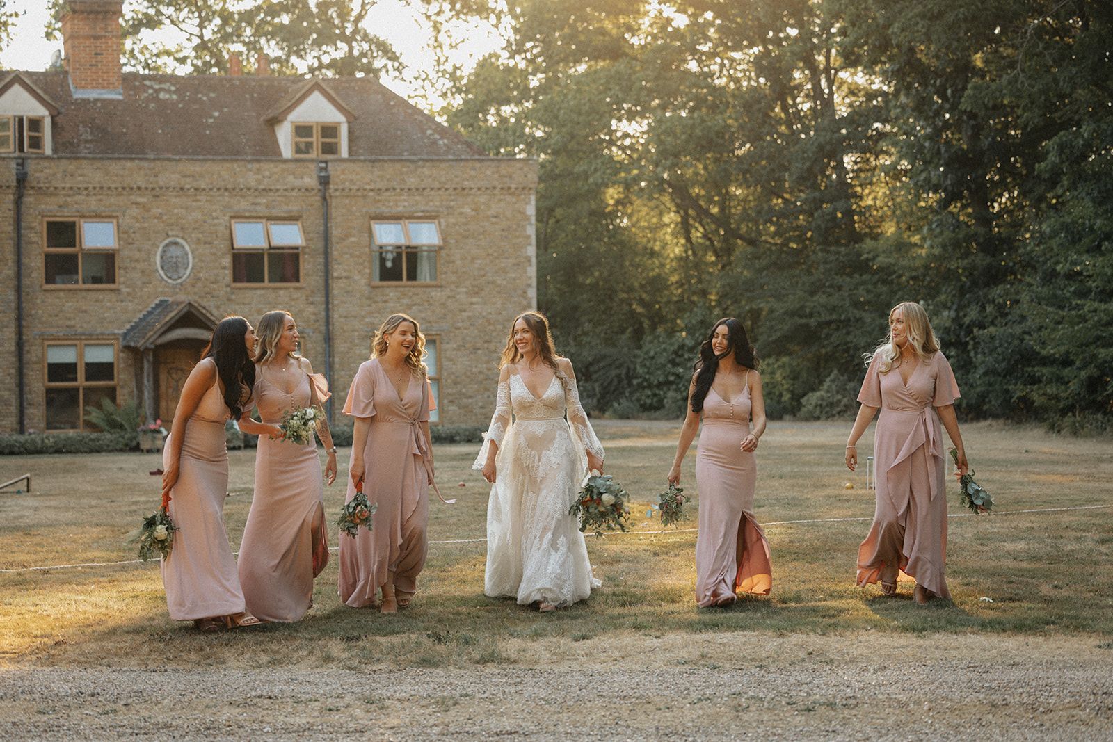 A bride and her bridesmaids are walking in front of a large building.