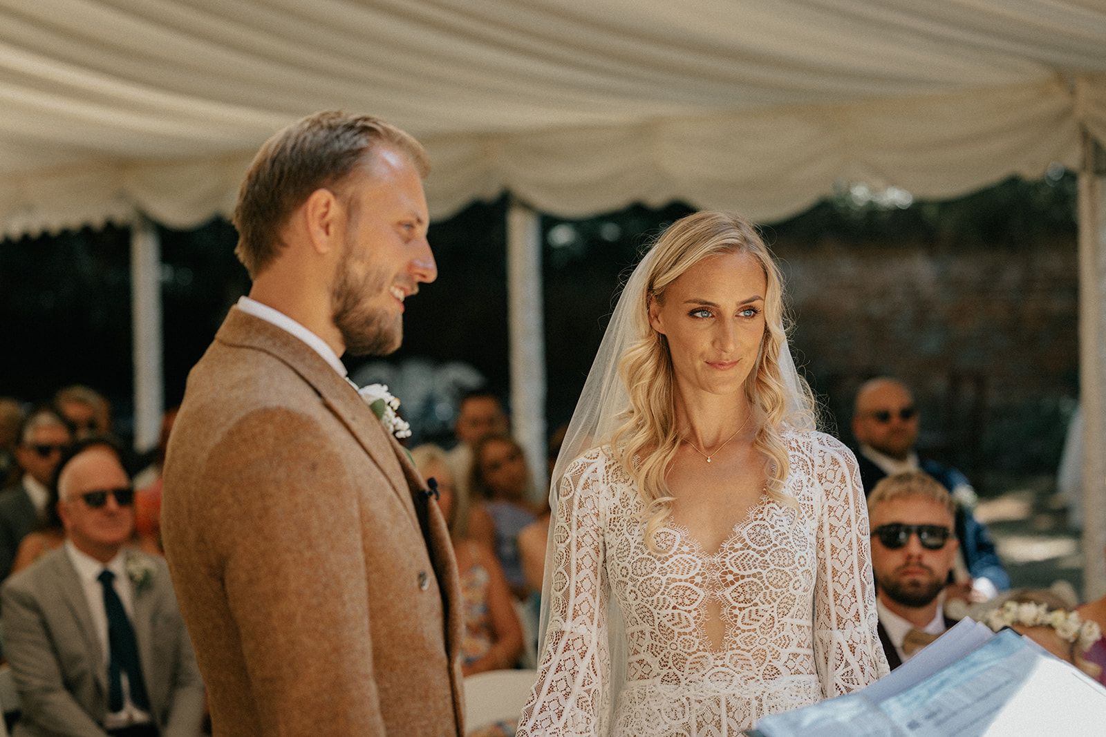 A bride and groom are holding hands during their wedding ceremony.