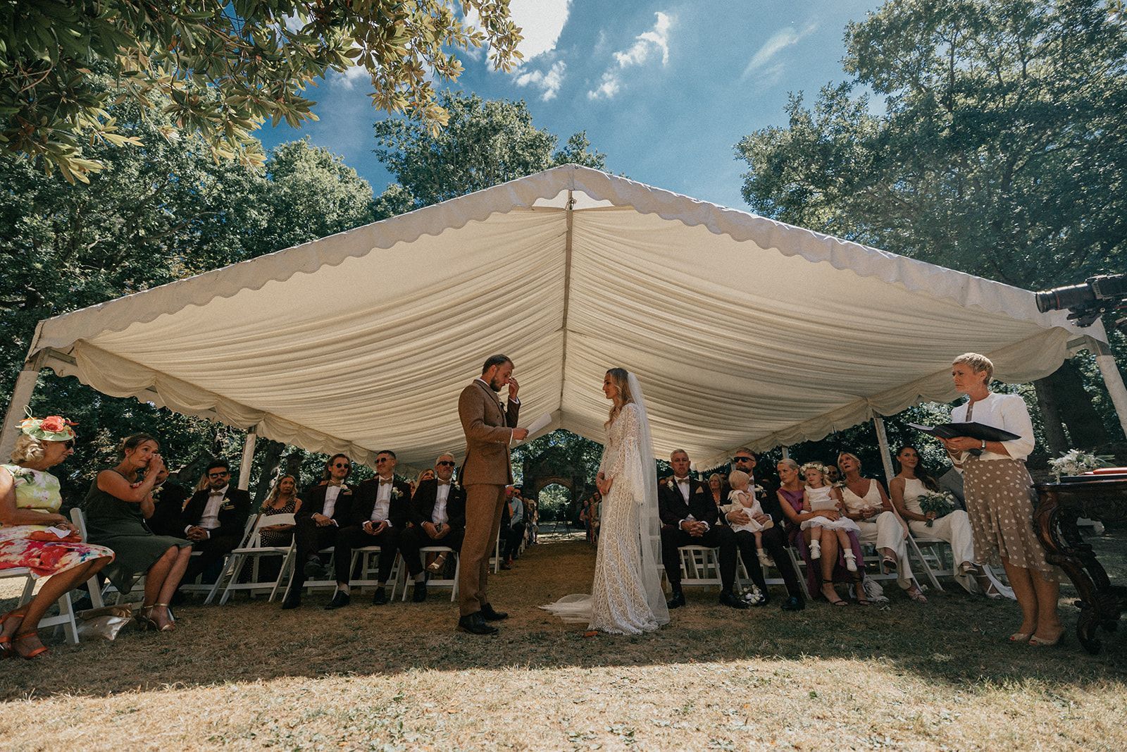 A bride and groom are getting married under a tent.