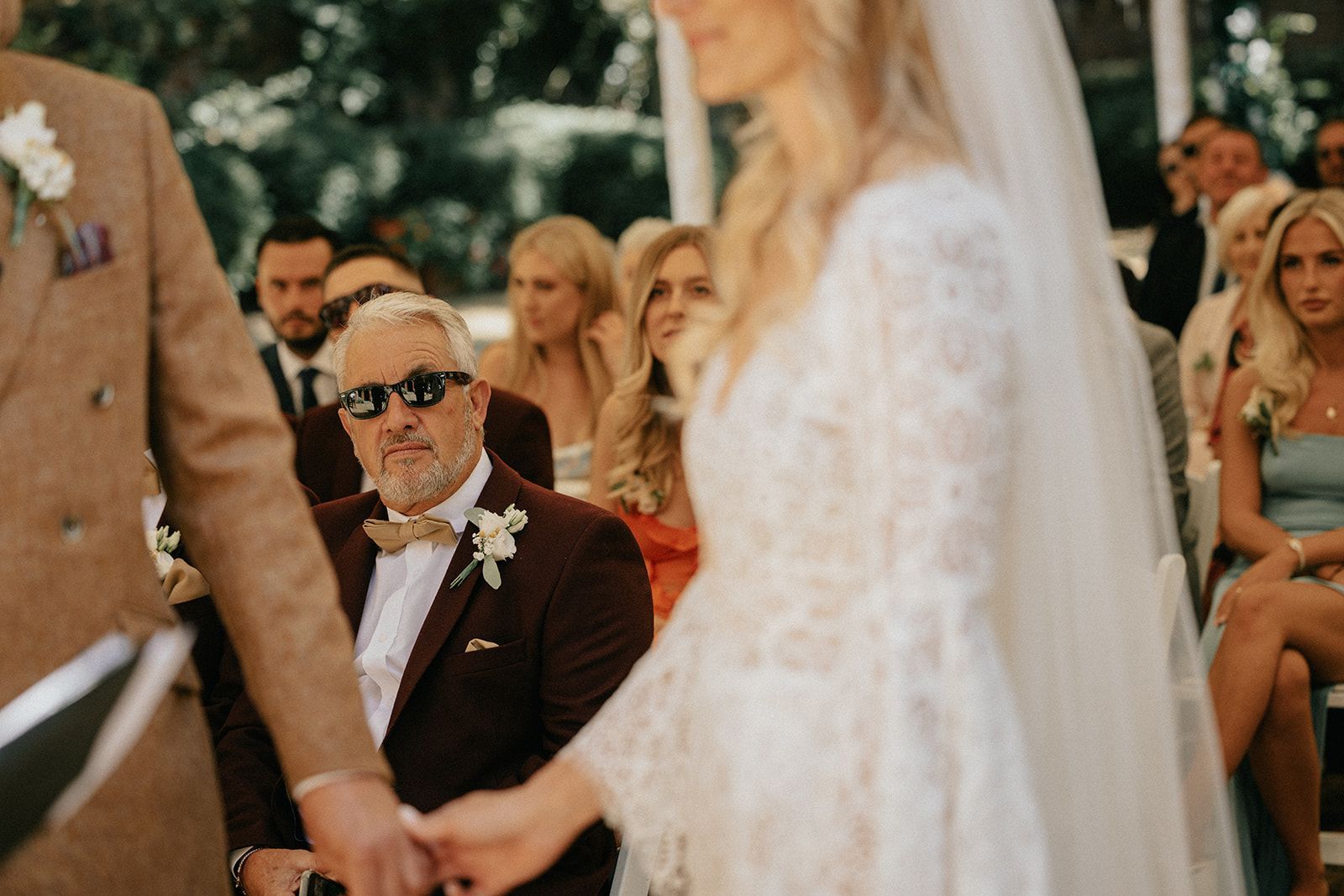 A bride and groom are holding hands during their wedding ceremony.