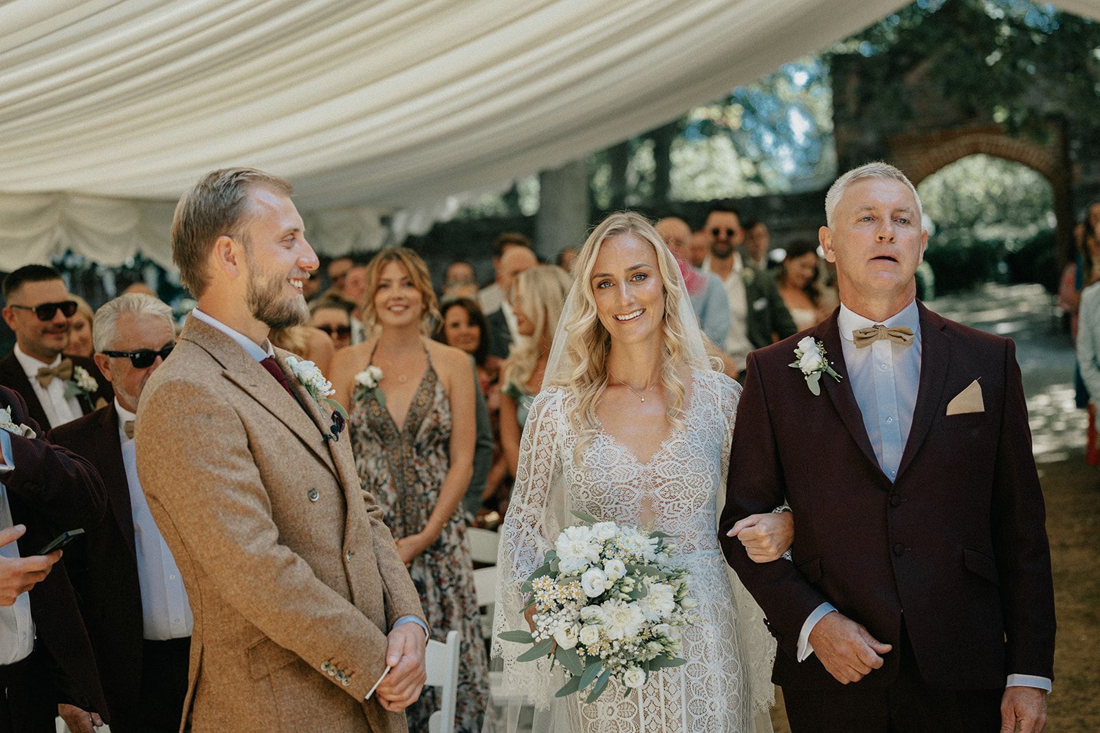 A bride and groom are walking down the aisle at their wedding.