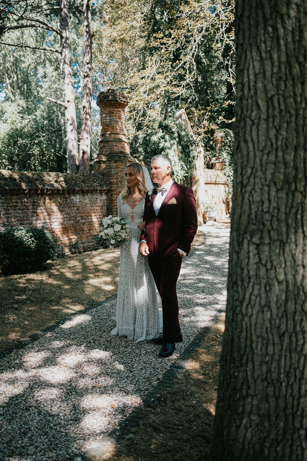A bride and groom are standing next to each other in the woods.