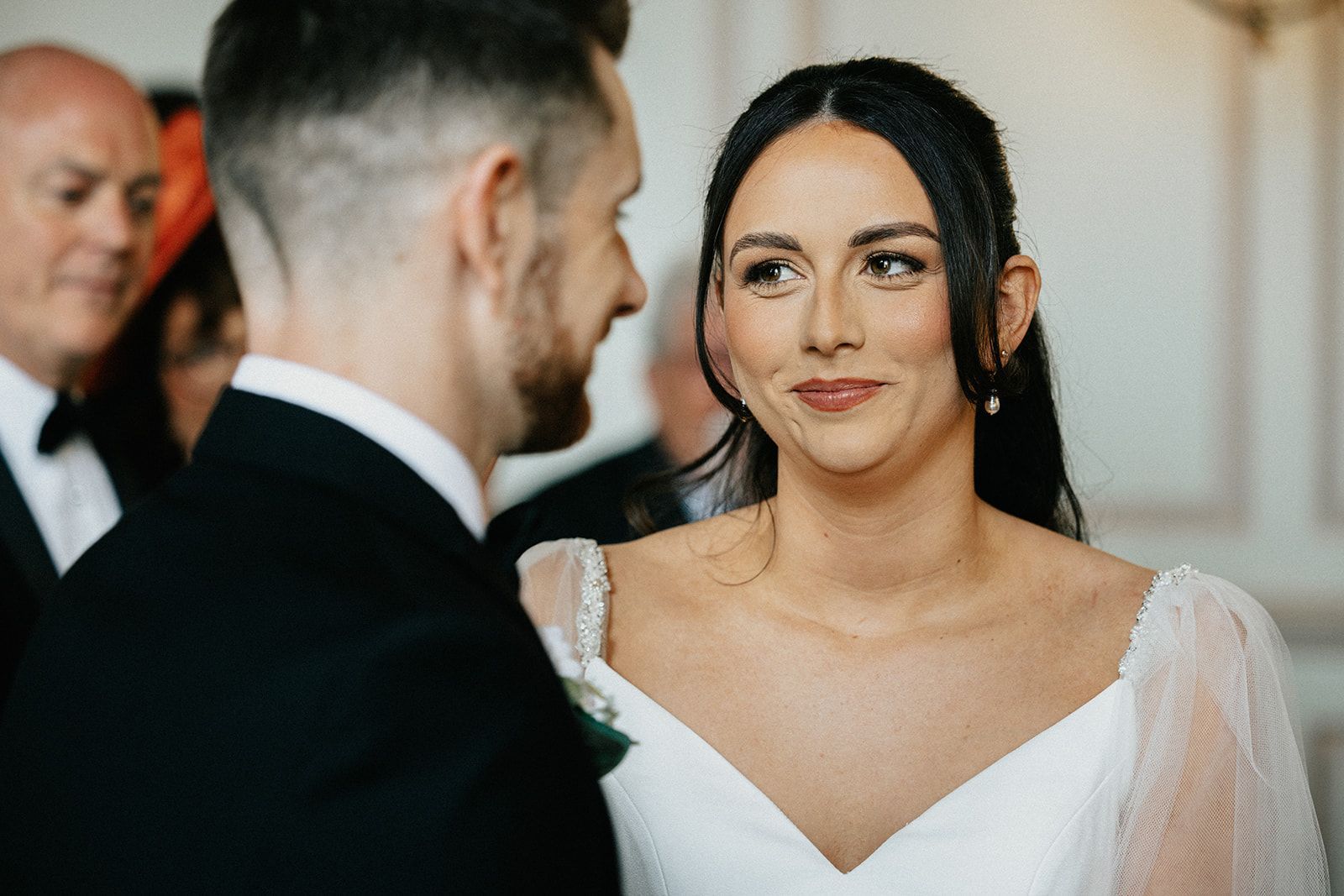 A bride and groom are looking at each other during their wedding ceremony.